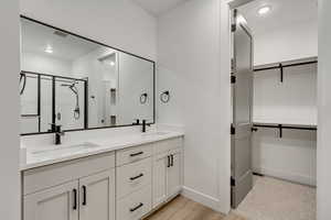 Bathroom with vanity, hardwood / wood-style flooring, and walk in shower