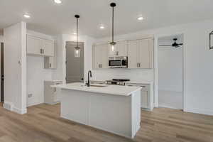 Kitchen with sink, decorative light fixtures, an island with sink, and appliances with stainless steel finishes