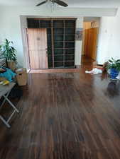 Living room featuring dark wood finished floors and a ceiling fan