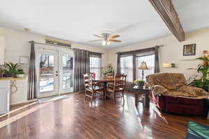 Dining space with beamed ceiling, plenty of natural light, and dark wood-type flooring