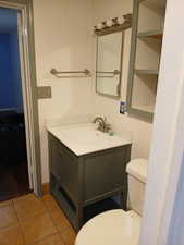 Bathroom featuring tile patterned flooring, toilet, and vanity