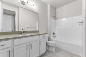 Full bathroom featuring vanity, toilet, bathing tub / shower combination, and tile patterned flooring