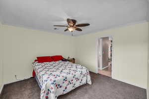 Bedroom featuring ceiling fan, ornamental molding, and carpet