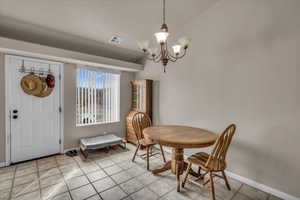 Tiled dining room featuring a notable chandelier