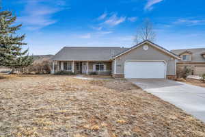 Single story home featuring a garage and a porch