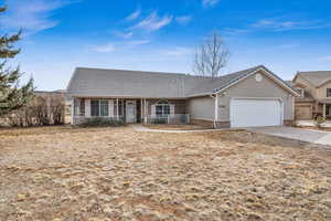 Ranch-style home with a garage and covered porch