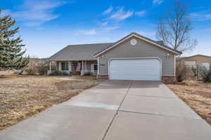 Ranch-style home with a garage and covered porch