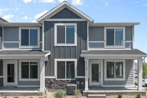 View of front of property featuring cooling unit and covered porch