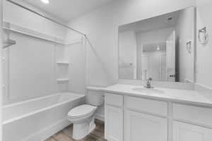 Full bathroom featuring vanity, hardwood / wood-style flooring,  shower combination, and toilet