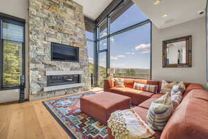 Living room featuring light hardwood / wood-style flooring, a fireplace, plenty of natural light, and expansive windows