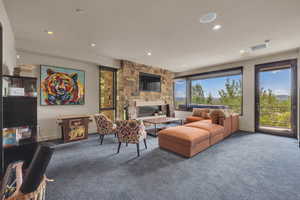 Living room with a stone fireplace and carpet