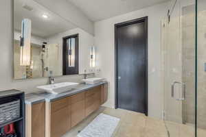 Bathroom with vanity, an enclosed shower, and tile patterned floors