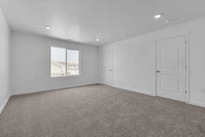 Carpeted empty room with a textured ceiling