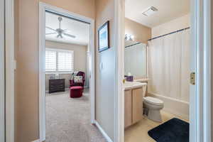 Full bathroom with vanity, ceiling fan, toilet, and shower / bath combo with shower curtain