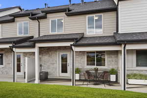 Rear view of property with a yard, central AC, and a patio area