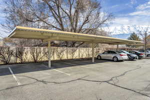 Single Covered Parking Space and One Uncovered Parking space for this unit: View of vehicle parking with a carport and a mountain view