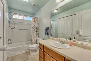 Full bathroom featuring tile patterned flooring, vanity, shower / bath combination with curtain, and toilet