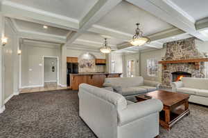 Clubhouse: Carpeted living room with coffered ceiling, beam ceiling, and a fireplace