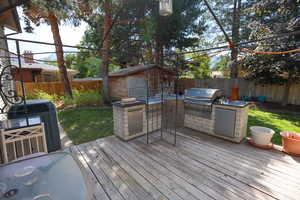 Wooden deck with a storage shed, grilling area,