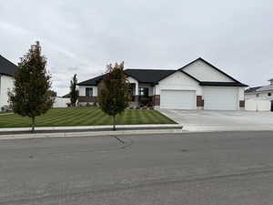 View of front facade featuring a garage and a front yard