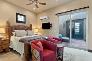 Bedroom featuring ceiling fan, access to exterior, light tile patterned floors, and an AC wall unit