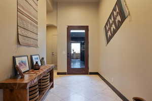 Tiled entryway featuring a towering ceiling