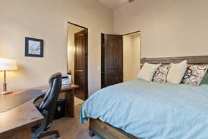 Carpeted bedroom featuring vaulted ceiling