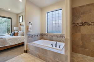 Bathroom featuring tile patterned flooring and tiled bath