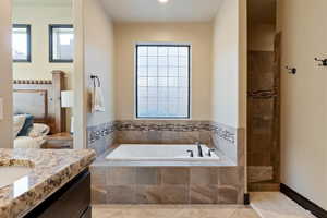 Bathroom with tile patterned flooring, vanity, and plus walk in shower