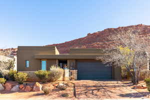 Pueblo revival-style home with a garage and a mountain view