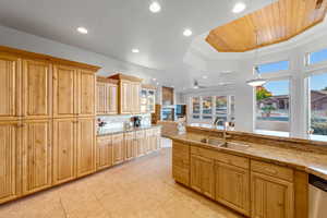 Kitchen featuring sink, tasteful backsplash, hanging light fixtures, a raised ceiling, and dishwasher