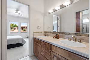 Bathroom featuring ceiling fan, vanity, tile patterned flooring, and decorative backsplash