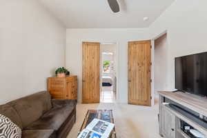 Living room with light colored carpet and ceiling fan