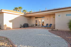 Rear view of house with a patio area and solar panels