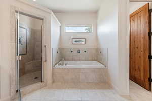 Bathroom featuring tile patterned floors and plus walk in shower