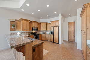 Kitchen with light tile patterned flooring, sink, a breakfast bar area, kitchen peninsula, and stainless steel appliances