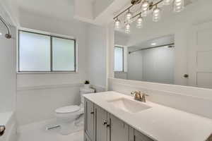 Bathroom featuring vanity, tile patterned floors, and toilet