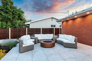 Patio terrace at dusk featuring an outdoor living space with a fire pit