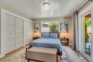 Bedroom featuring multiple closets, access to exterior, and light hardwood / wood-style floors