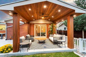 Patio terrace at dusk featuring an outdoor living space and ceiling fan