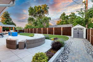 Exterior space featuring a storage unit, an outdoor hangout area, and a patio