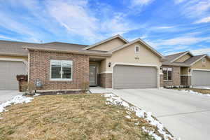 View of front of property with a garage and a front lawn