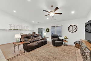 Living room featuring vaulted ceiling and ceiling fan