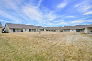 Rear view of property with a yard