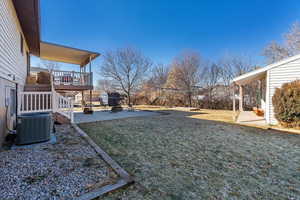 View of yard with central AC unit, a patio, and a wooden deck