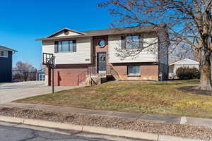 Split foyer home featuring a garage and a front lawn