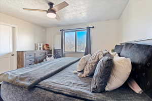 Bedroom featuring ceiling fan and a textured ceiling