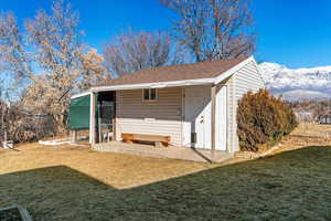 View of outbuilding featuring a mountain view and a lawn