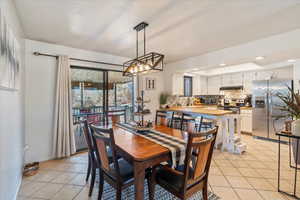 Dining space featuring light tile patterned floors and a textured ceiling