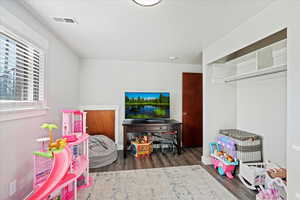 Playroom featuring dark wood-type flooring and a textured ceiling